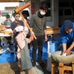 青い服を着ている人が餅つきマイスター